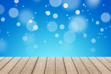 Wood table with blue color background with bokeh.