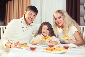 Family eating dinner at a dining table, Round table, pizza, orange, house made of wood