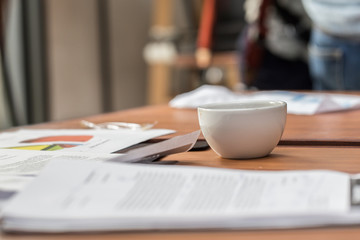 White Coffee cup on work table with sale report