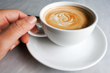Hand with a cup of coffee after work. Bitter sweet of coffee, boost up our body.