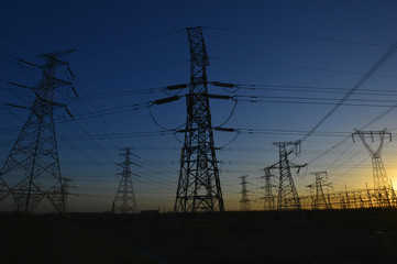 The silhouette of the evening electricity transmission pylon