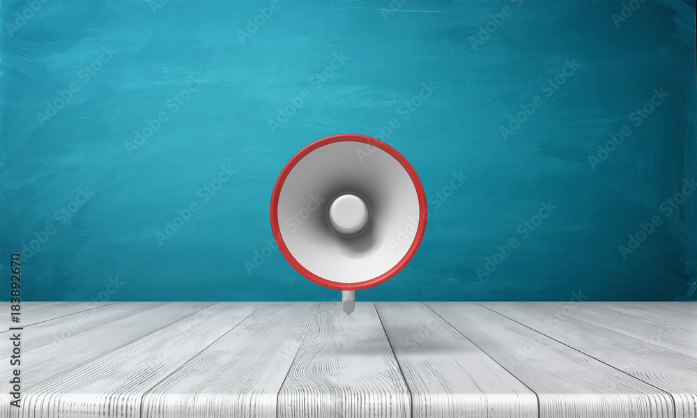Poster 3d rendering of a single red and white megaphone hanging vertically above a wooden desk.