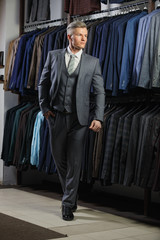 client is elegant guy in jacket. In the background classic suits and jackets