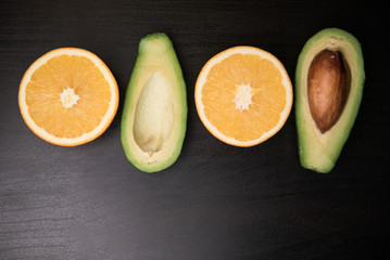 avocado and orange on a dark background