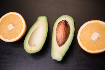 avocado and orange on a dark background