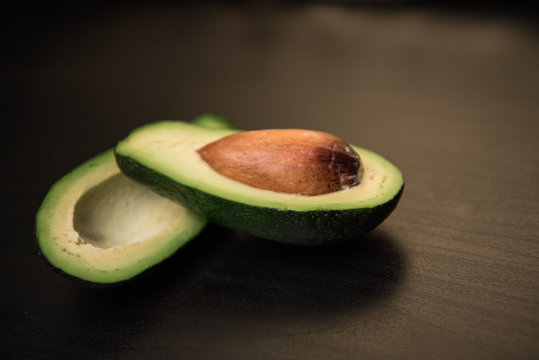 Fresh avocado on dark background. Vegetarian food concept. Top view.
