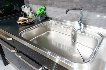 Angle view of kitchen sink with silver faucet in kitchen room, modern counter with sink in kitchen room, interior design concept