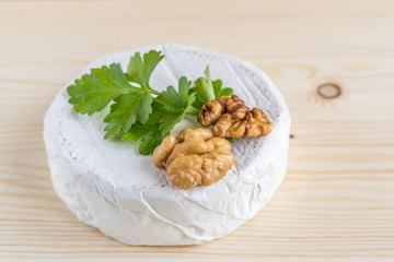 Fototapeta premium camembert, parsley and walnut on wooden desk