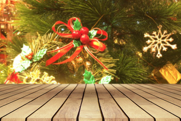 Perspective empty wooden table and christmas tree with snowing and blur decoration at coffee shop background, for product display montage or design layout.