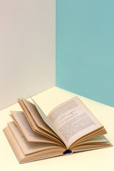 Still life with an open book on a colored background