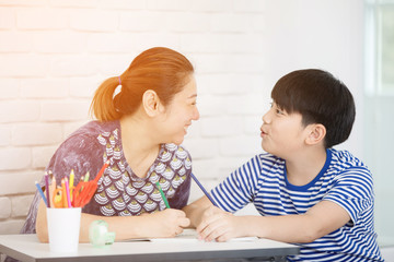 Asian boy with mother teaching and learning your homework at home