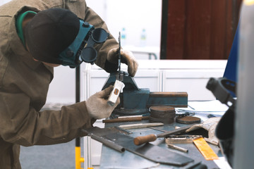 Man worker making workpieces with hummer - workshop