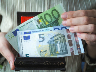 Euro banknotes in his hands and an old box. 