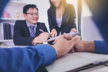Secretary showing document to her boss for signature while meeting in the office