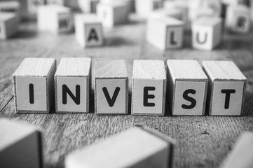 concept mot formé avec des lettres en bois - invest