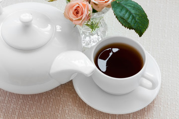 teapot, cup, and roses on a plate