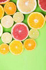 on a green background, in the upper left corner of many cut fruits with vitamin C