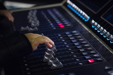 Close up of child adjusting volume on audio mixer.