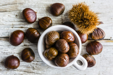 Edible chestnuts, marron on wooden rustic background.