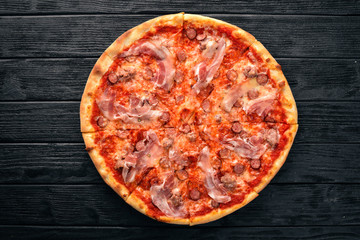 Pizza Lardon. Bacon, cherry tomatoes, sausage salami. On a wooden background. Top view.