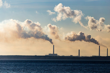 Industrial smoke from a plant on the shore of a lake