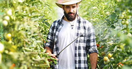 Young farmer protecting his plants with chemicals