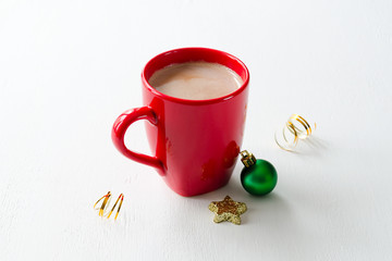 Red mug of cocoa with milk and Christmas toy