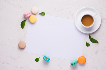 Fototapeta na wymiar Colorful flat lay with flowers macaroons and cup of tea. Spring concept.