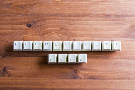 Resolutions 2018 on computer keyboard keys buttons on a wooden background.