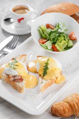 Toasts with bacon, egg Benedict and fresh salad. Breakfast conception