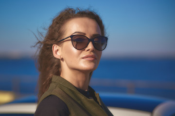 Female beauty concept. business young beautiful woman in sunglasses against the blue sky at sunset