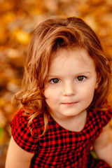 Fototapeta premium The small girl stands near trees