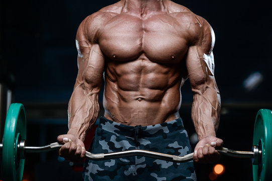 Brutal strong bodybuilder athletic men pumping up muscles with dumbbells.