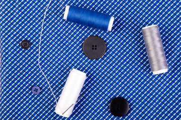 Items for sewing clothes. Sewing buttons, spools of thread and cloth. Top view.
