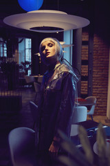 Futuristic neon lighted portrait of a woman with white bob hairstyle wearing silky blouse and...