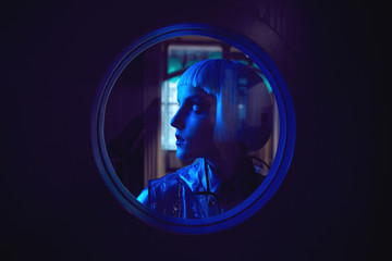 Futuristic neon lighted portrait of amazing woman with white bob hairstyle wearing silky blouse and...
