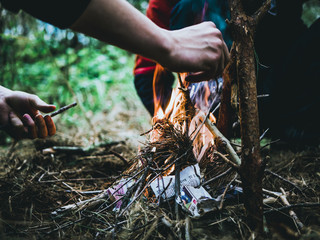 close up shot of man making a fire in the forest