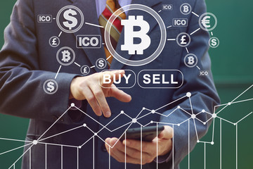 Businessman presses currencies button ICO Initial Coin Offering chart diagram on virtual digital electronic interface in phone.