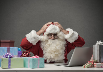 Stressed Santa connecting with his laptop