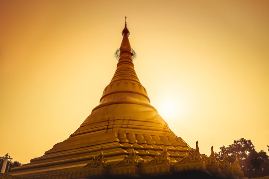 magical sunset golden with a buddhist stupa in nepal.