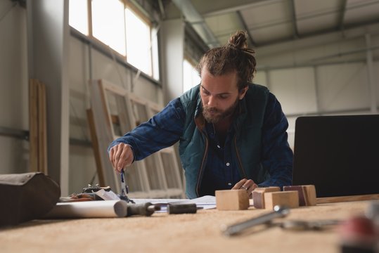Carpenter drawing with compass on paper