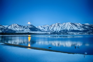 Picturesque scenery of winter with golden moonset over Lake Tahoe.
