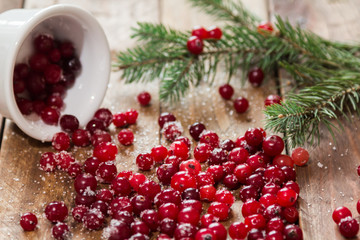 Cranberry with sugar scattered on a wooden table