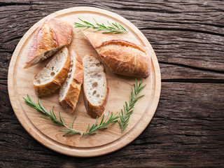 Slices of ciabatta with rosemary herb on the serving wooden tray