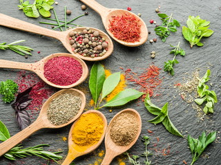 Assortment of colorful spices in the wooden spoons.