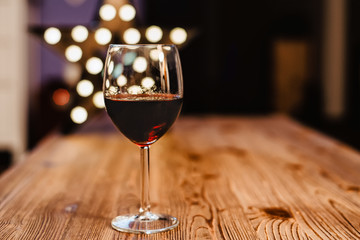 a glass of wine on the background of holiday lights