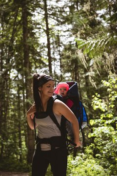 Mother carrying her baby in backpack carrier
