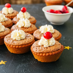 Brownie mins pies on a black background. Square image.
