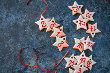 Fototapeta na wymiar Advent gingerbread star cookies on a blue stone background.