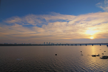 Golden light through the clouds. Legendary metal Bridge Paton at dawn, winter morning landscape photo. Kyiv, Ukraine. Selective focus with wide angle lens